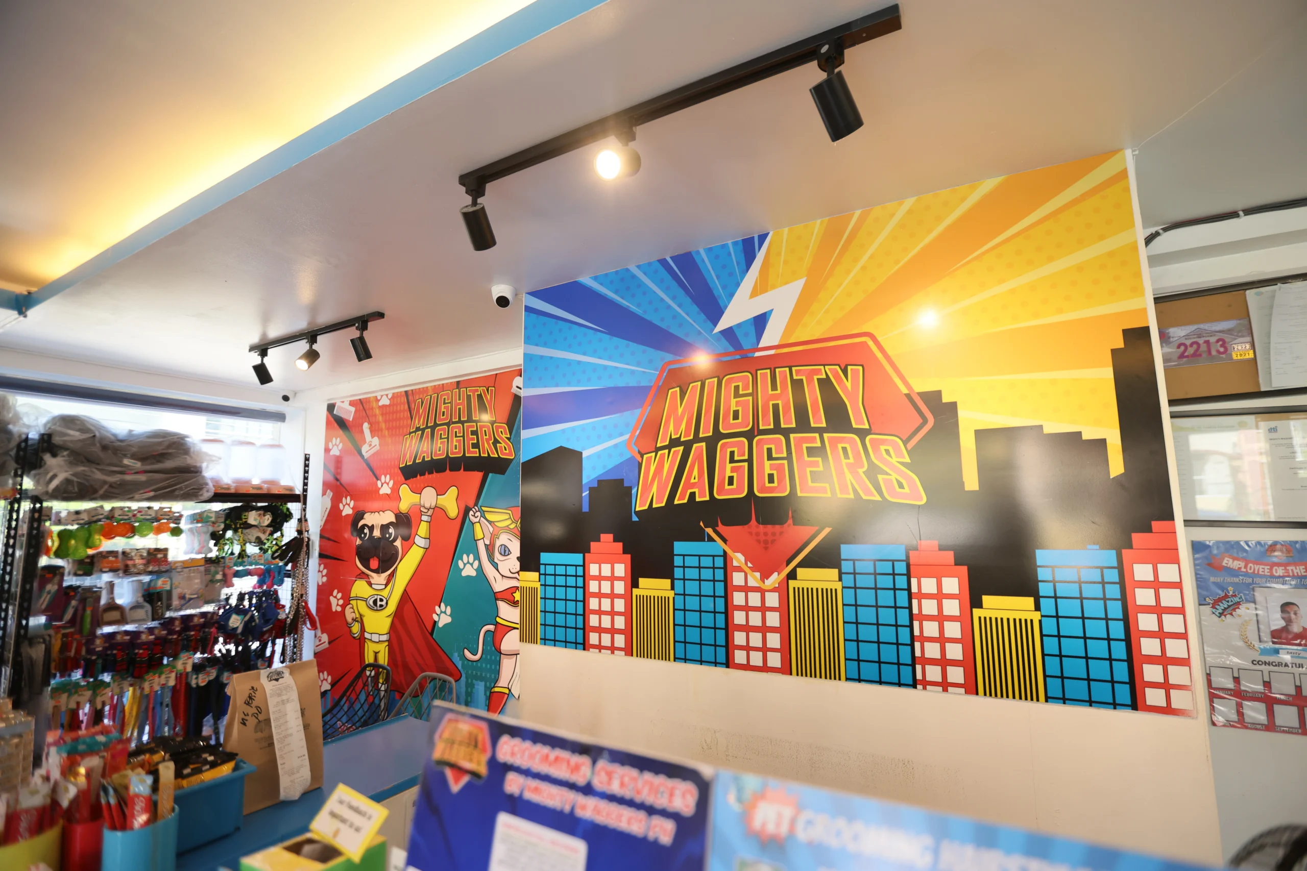 The Mighty Waggers reception area bursts with superhero-themed wall art and vibrant pet branding, creating a lively and inviting space for this fun-loving dog grooming and care center.